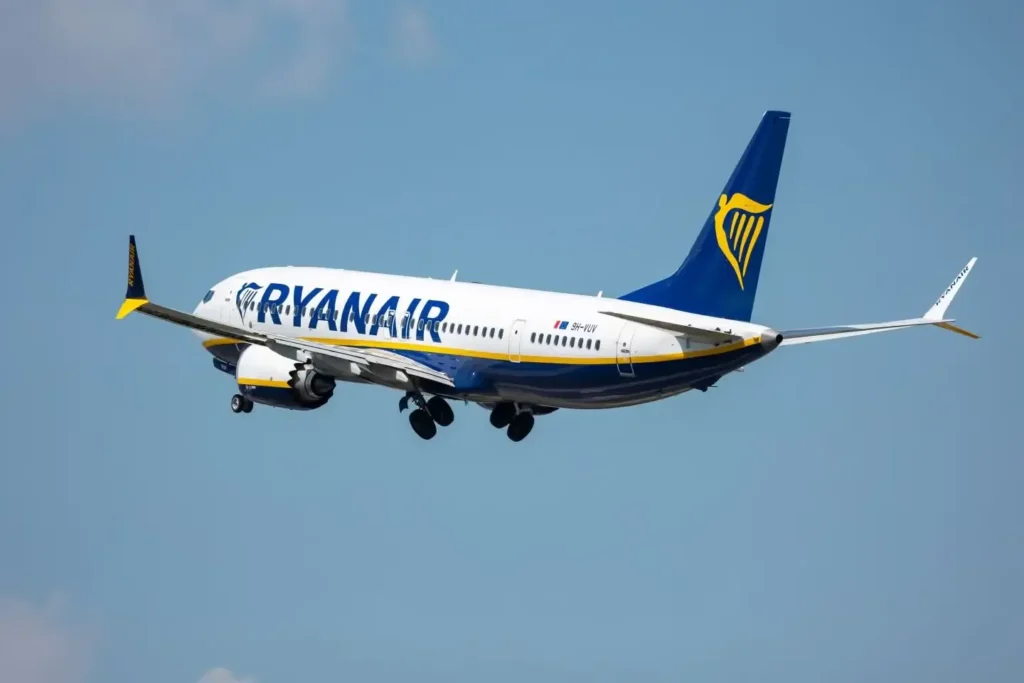 Avion Ryanair bleu et blanc en vol entre deux villes du Maroc, sur fond de ciel bleu, logo visible sur la dérive et le fuselage.